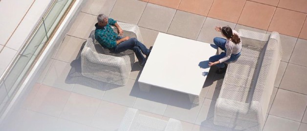 two people sitting on a couch and talking each other