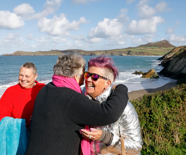Three patients meet closed to a beach and hugging