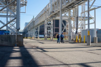 two man are walking in a factory