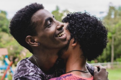 Two men hugging each other in a park.