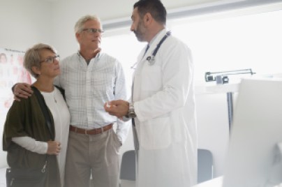A doctor is talk with a couple of senior people