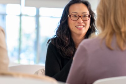 two women are talking in the office