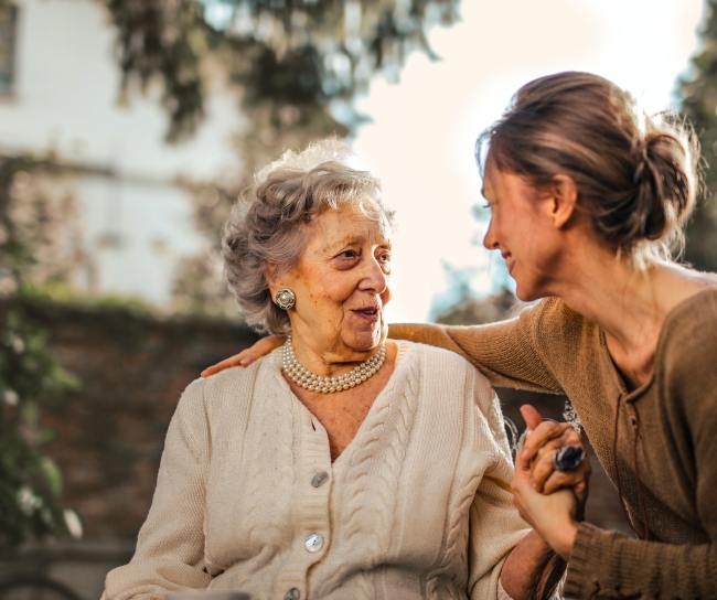 A woman talking with a senior woman
