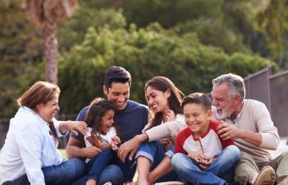 a family siting on grass in a park