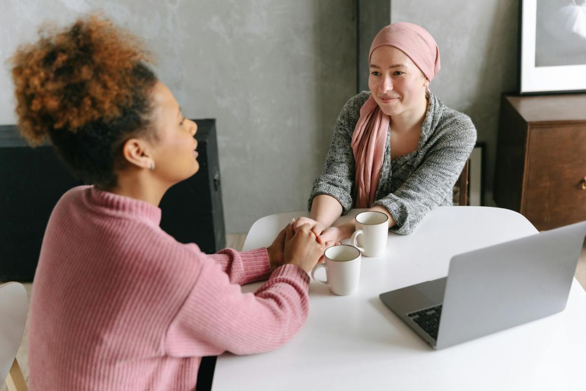 two women are talking and holding their hands.